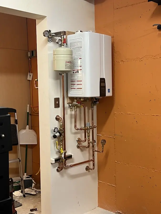 Plumbing technician inspecting water heater connections in Fair Oaks
